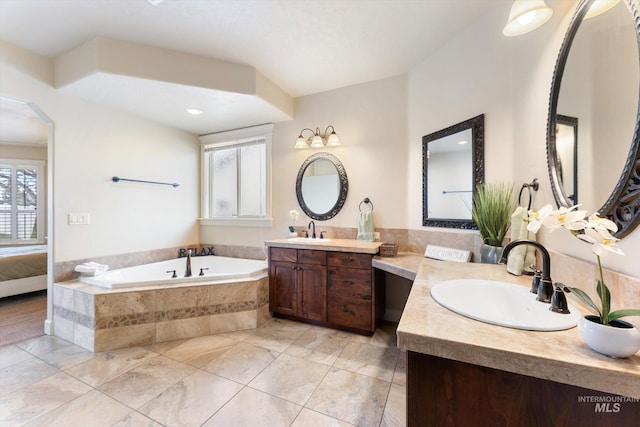 ensuite bathroom with plenty of natural light, a sink, and ensuite bath