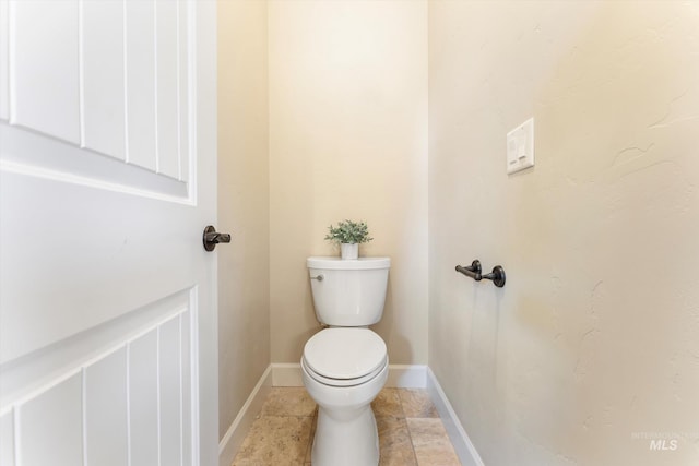 bathroom with toilet, baseboards, and tile patterned floors