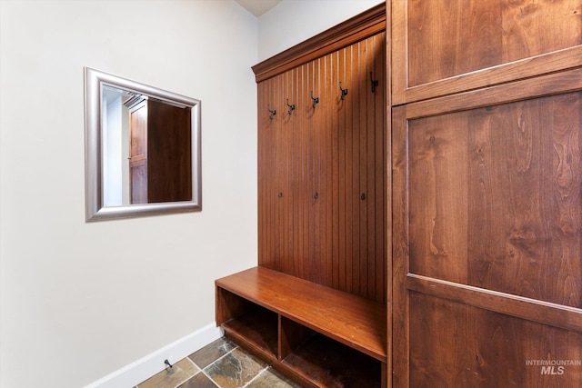 mudroom with stone finish flooring and baseboards