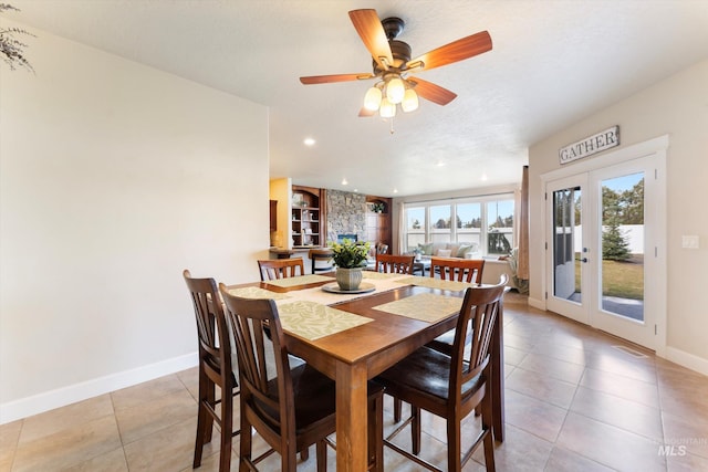 dining room featuring light tile patterned floors, french doors, a textured ceiling, and baseboards