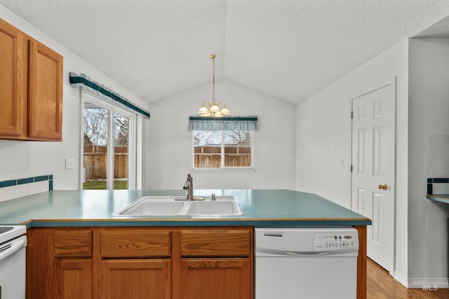 kitchen with lofted ceiling, a textured ceiling, white appliances, a sink, and pendant lighting