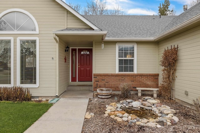 doorway to property featuring crawl space, a shingled roof, and brick siding