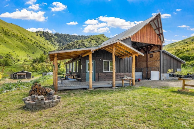255 Seven U Ranch Rd, Lucile, ID 83542 - view of side of property featuring a yard, an outdoor fire pit, a deck with mountain view, and metal roof
