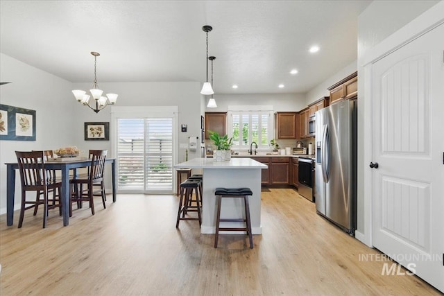 5707 W Elk Trail St Unit 630, Boise, ID 83714 - kitchen featuring stainless steel appliances, light wood-style floors, a chandelier, light countertops, and a center island