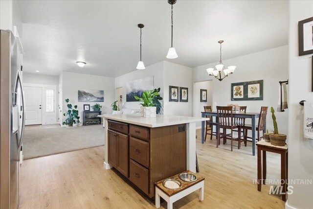 5707 W Elk Trail St Unit 630, Boise, ID 83714 - kitchen featuring stainless steel fridge, light wood-type flooring, a chandelier, and hanging light fixtures