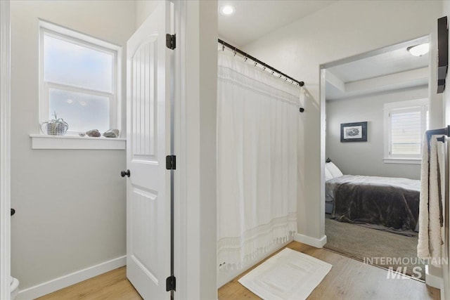 5707 W Elk Trail St Unit 630, Boise, ID 83714 - bathroom featuring connected bathroom, wood finished floors, a shower with shower curtain, and baseboards