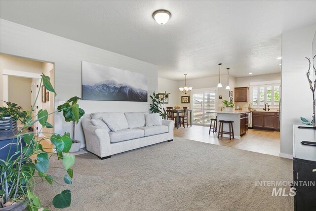 5707 W Elk Trail St Unit 630, Boise, ID 83714 - living room featuring a chandelier, light carpet, and baseboards