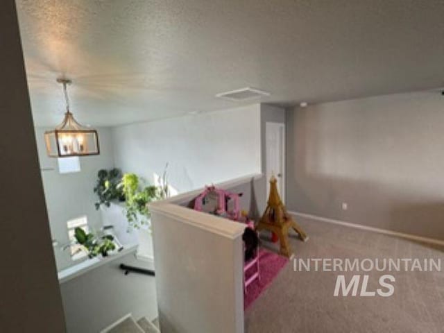 rec room with carpet flooring, baseboards, and a textured ceiling