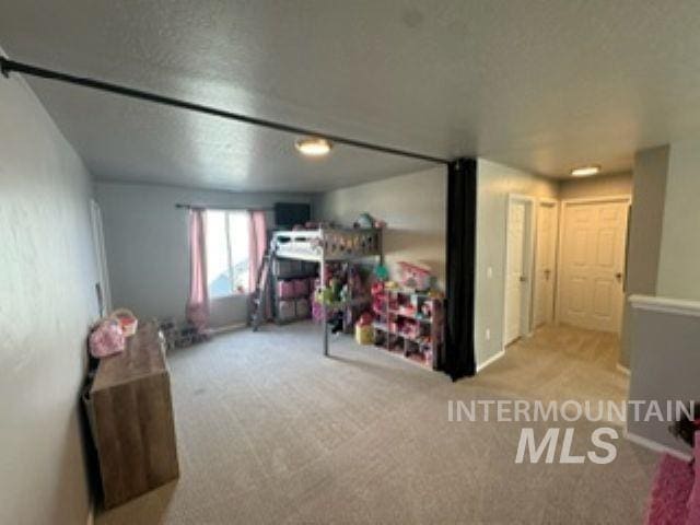 recreation room featuring carpet flooring and a textured ceiling