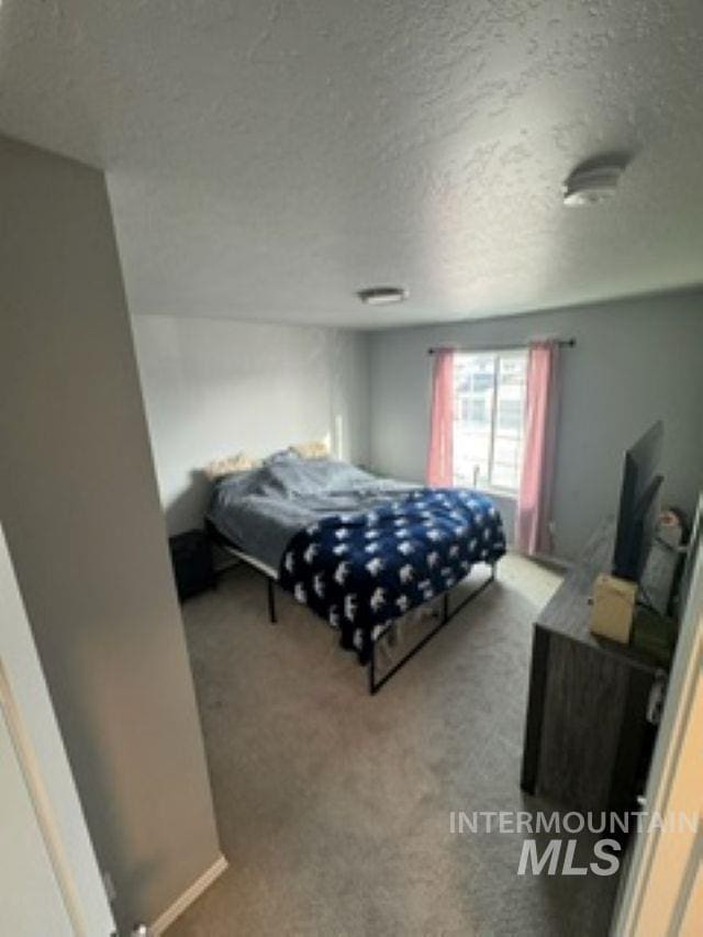 bedroom featuring carpet floors and a textured ceiling