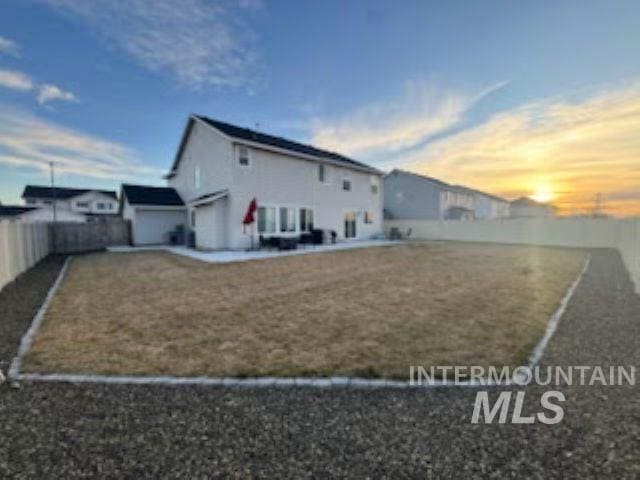 rear view of property with a lawn and a fenced backyard