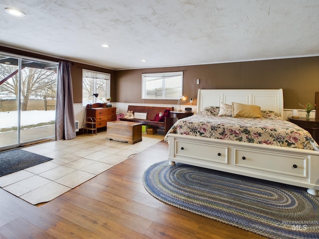 bedroom with access to exterior and light hardwood / wood-style floors