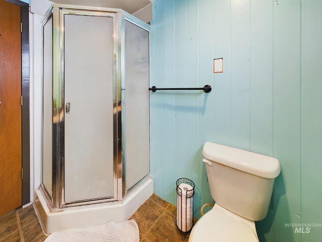 bathroom with tile patterned floors, a shower with door, and toilet