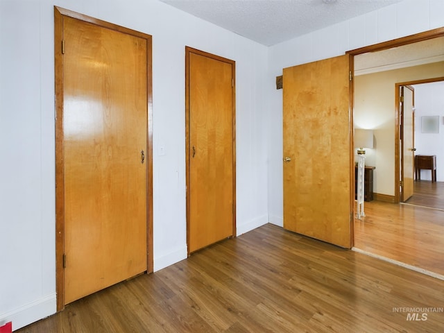 unfurnished bedroom featuring hardwood / wood-style floors and a textured ceiling