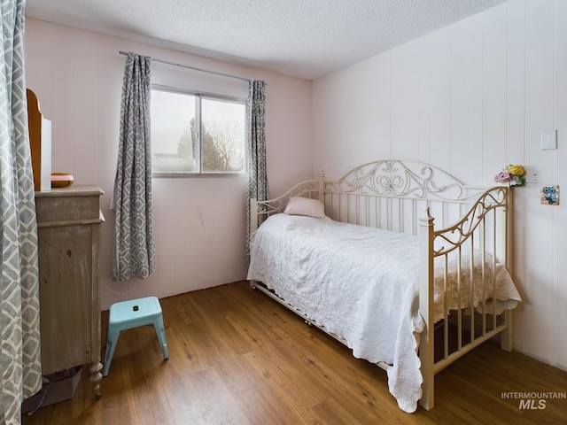 bedroom featuring hardwood / wood-style flooring and a textured ceiling