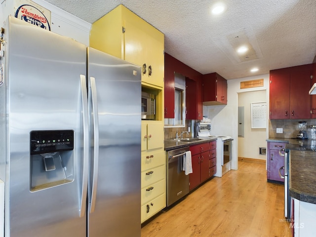 kitchen featuring stainless steel appliances, sink, decorative backsplash, and light hardwood / wood-style flooring