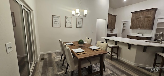 dining area with an inviting chandelier, sink, and dark hardwood / wood-style floors