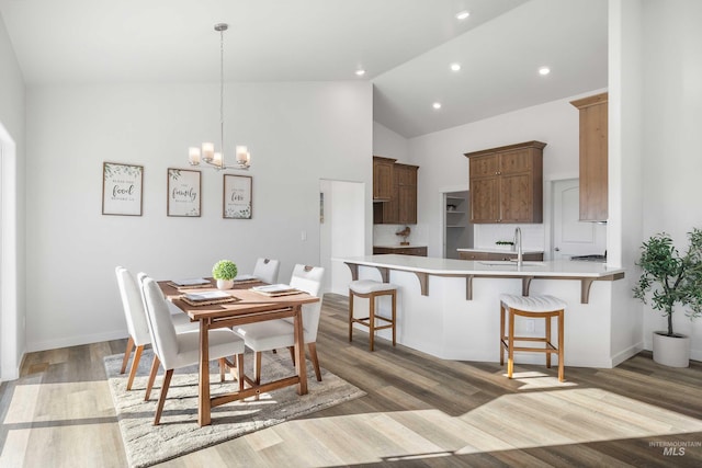 205 W 13th Ave, Jerome, ID 83338 - dining room with a chandelier, light wood-style flooring, recessed lighting, baseboards, and high vaulted ceiling