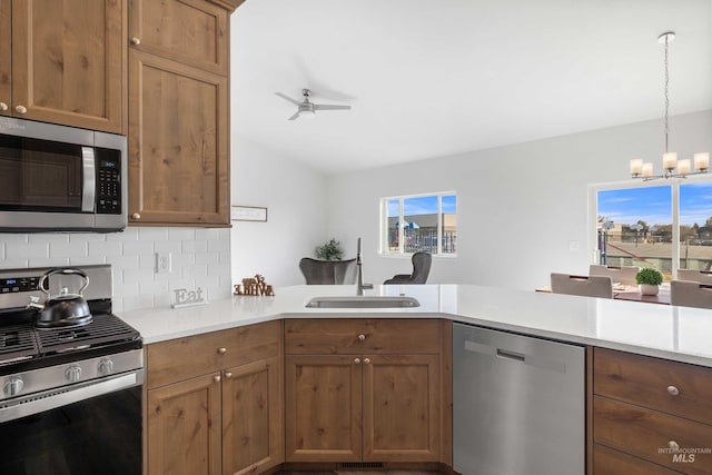 205 W 13th Ave, Jerome, ID 83338 - kitchen with appliances with stainless steel finishes, a sink, decorative backsplash, ceiling fan, and a chandelier