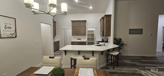 205 W 13th Ave, Jerome, ID 83338 - kitchen with a sink, a peninsula, dark wood-type flooring, a chandelier, and a breakfast bar area