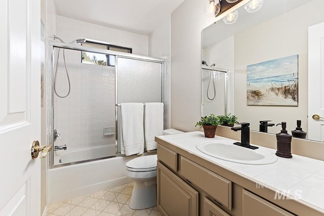 bathroom with enclosed tub / shower combo, vanity, and toilet