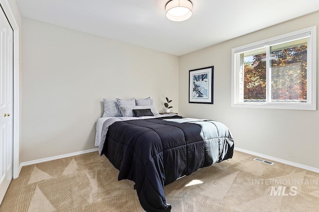 bedroom featuring light carpet, visible vents, and baseboards