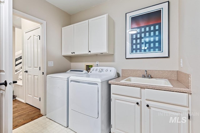 laundry area with light floors, a sink, cabinet space, and washer and dryer