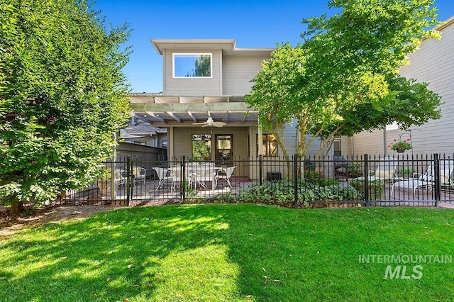 rear view of house with fence private yard, a pergola, and a yard