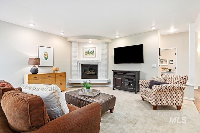 living area featuring light carpet and a fireplace