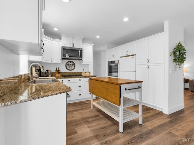 248 N Palmetto Dr, Eagle, ID 83616 - kitchen with appliances with stainless steel finishes, dark wood-style flooring, white cabinets, recessed lighting, and dark stone countertops