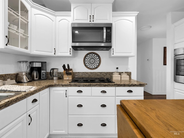 248 N Palmetto Dr, Eagle, ID 83616 - kitchen with stainless steel appliances, glass insert cabinets, white cabinetry, and dark stone counters