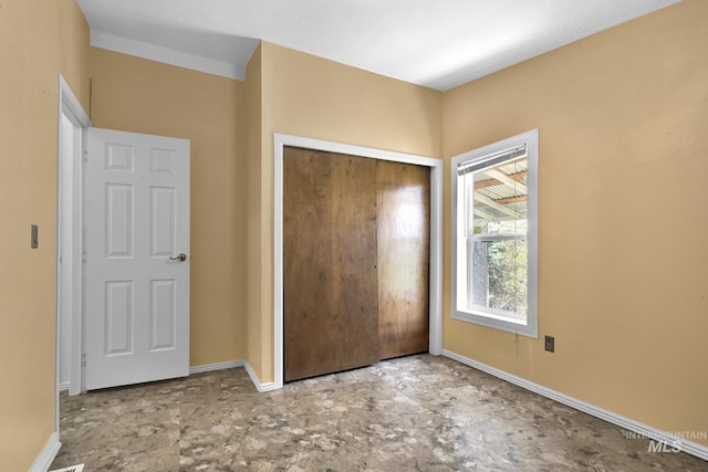 unfurnished bedroom featuring baseboards and a closet