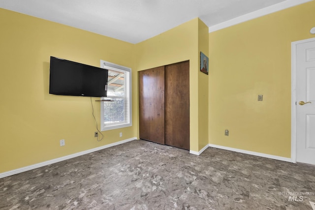 unfurnished bedroom with baseboards and a closet