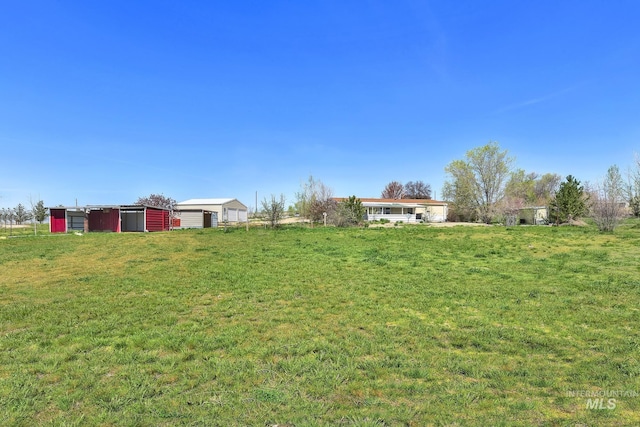 view of yard with a garage and an outbuilding