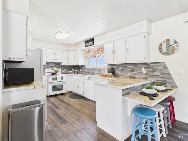 1929 S 2350 E, Malta, ID 83342 - kitchen featuring white appliances, a peninsula, white cabinetry, and dark wood-type flooring