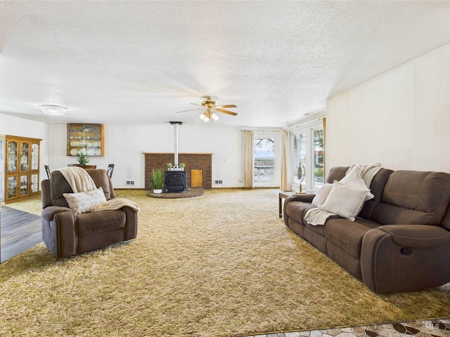 1929 S 2350 E, Malta, ID 83342 - living area featuring a wood stove, ceiling fan, a textured ceiling, and carpet flooring