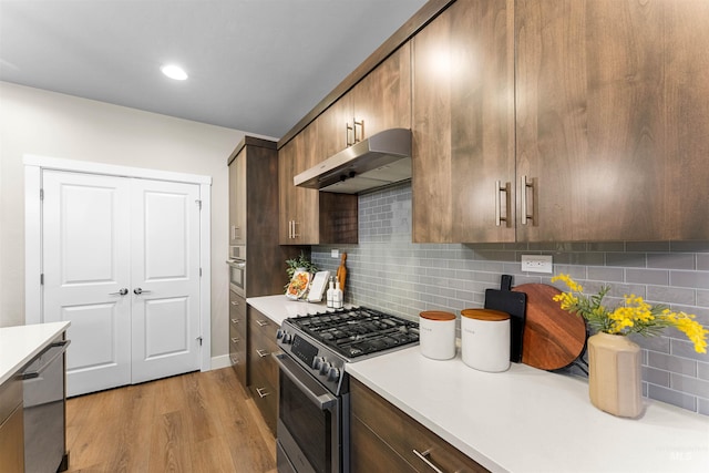 kitchen featuring decorative backsplash, stainless steel appliances, and light hardwood / wood-style floors