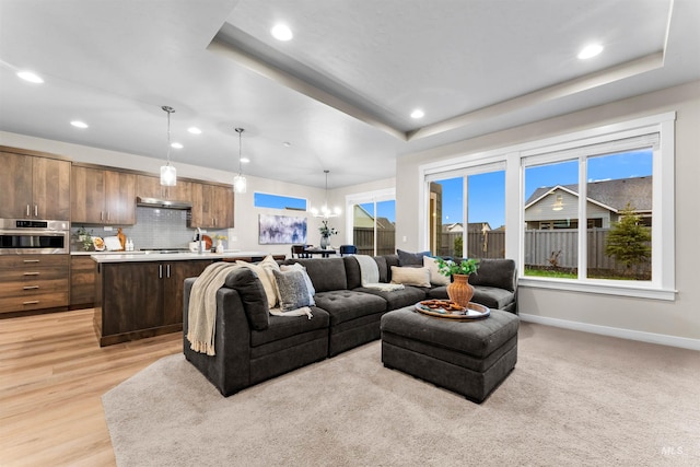 living room featuring light hardwood / wood-style floors and a raised ceiling