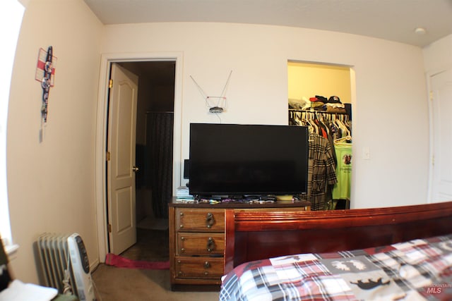 carpeted bedroom with a walk in closet