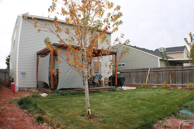 rear view of property with a yard and fence