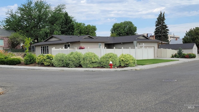 ranch-style house featuring a garage and fence