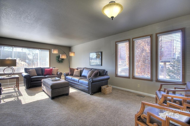 carpeted living area with a textured ceiling, visible vents, and baseboards