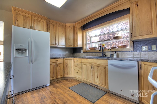 kitchen featuring a sink, light wood finished floors, white refrigerator with ice dispenser, and dishwasher