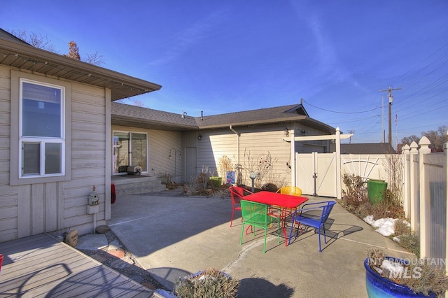 view of patio / terrace with a gate, fence, and outdoor dining area