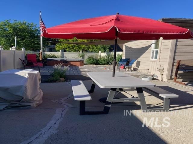 view of patio with fence and a hot tub