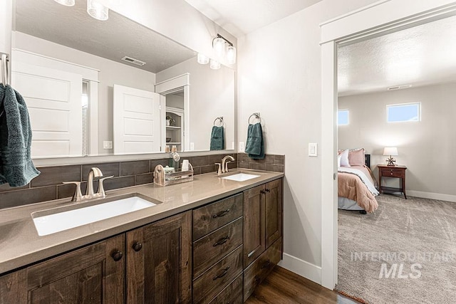59 S Ravine Way, Nampa, ID 83687 - ensuite bathroom featuring double vanity, tasteful backsplash, and baseboards