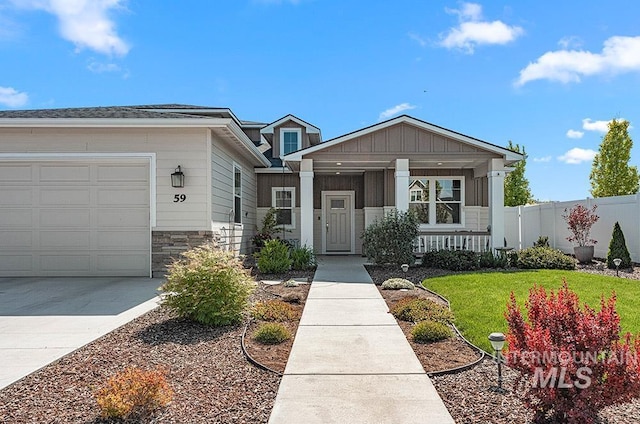 59 S Ravine Way, Nampa, ID 83687 - view of front of house featuring a porch, an attached garage, driveway, and stone siding