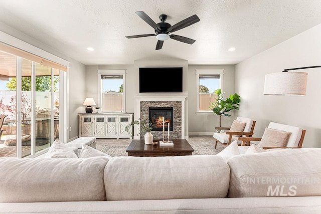 59 S Ravine Way, Nampa, ID 83687 - living area with plenty of natural light, a ceiling fan, a stone fireplace, baseboards, and recessed lighting