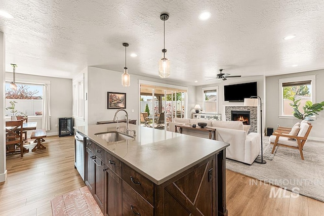 59 S Ravine Way, Nampa, ID 83687 - kitchen with a sink, dark brown cabinets, ceiling fan, light wood-style floors, and a textured ceiling