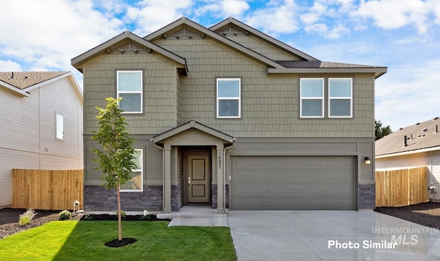 view of front of property with a garage, stone siding, concrete driveway, and fence